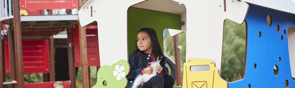 Girl resting in a playground playhouse 